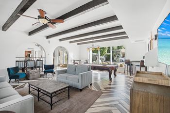 A modern living room with a large grey sofa and a wooden coffee table. at The Viridian Apartments, Scottsdale 85250